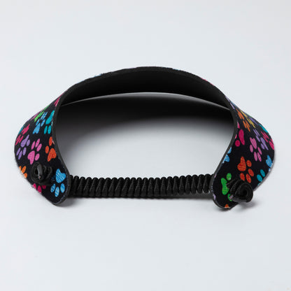 Black visor with colorful paw print design on a light gray background