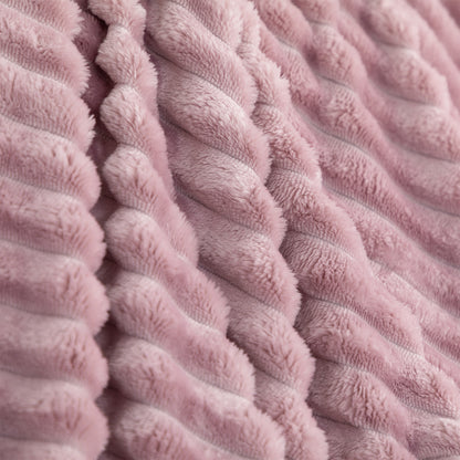 A close-up of a dusty pink textured throw blanket with a ribbed, corduroy-like plush surface.