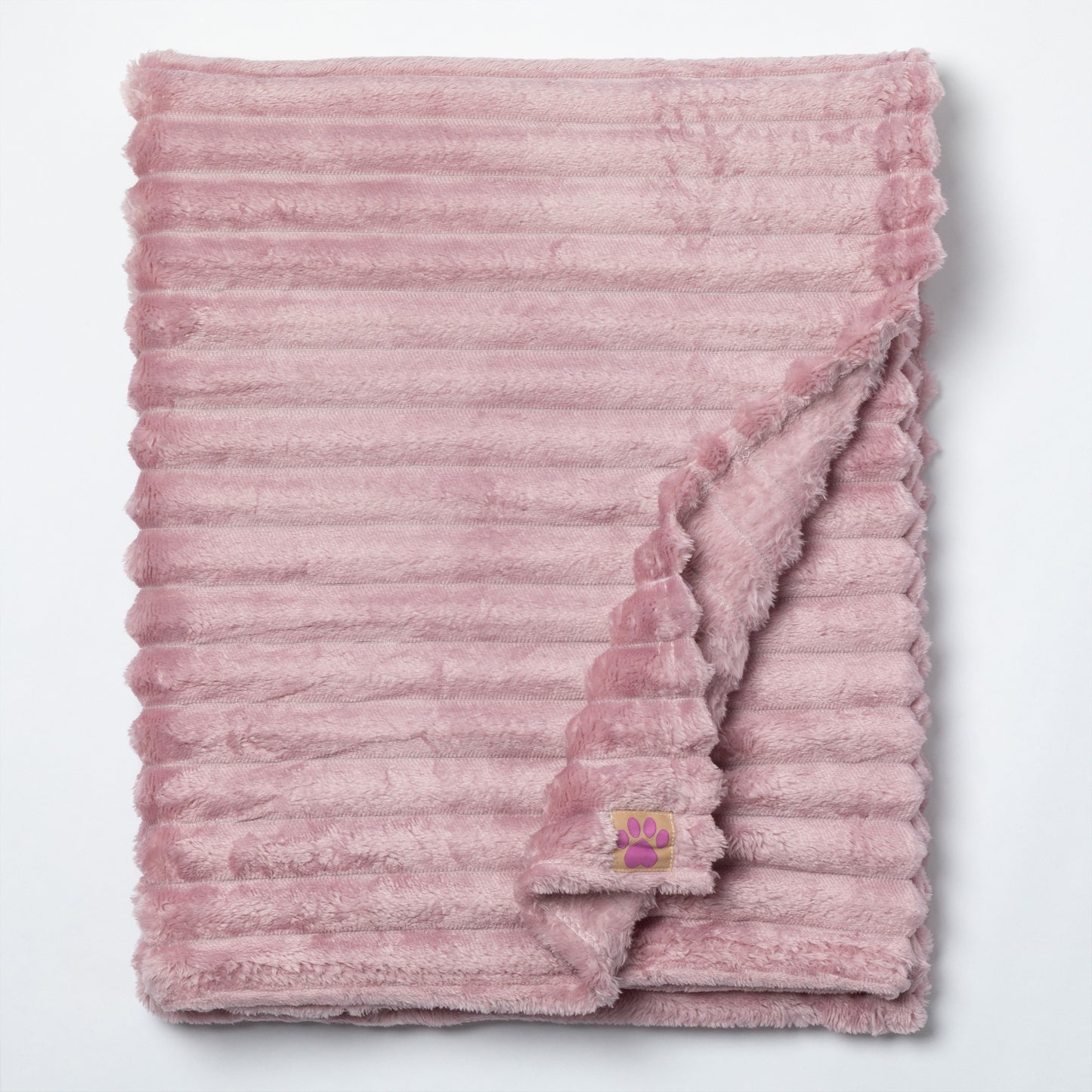 A dusty pink plush throw blanket with a ribbed corduroy-like texture, folded neatly on a white background with one corner folded over to show the soft reverse side.