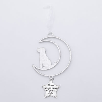 A silver metal pet memorial ornament featuring a crescent moon with a sitting dog silhouette and a dangling star charm that reads 'I look up and think of you at night', shown on a plain light gray background.