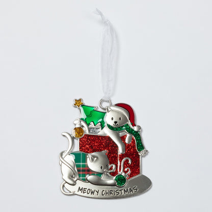 A silver-toned Christmas ornament featuring two white cats, one wearing a green Santa hat and scarf and the other sitting beside a red glittery gift box with the text 'MEOWY CHRISTMAS' at the bottom.