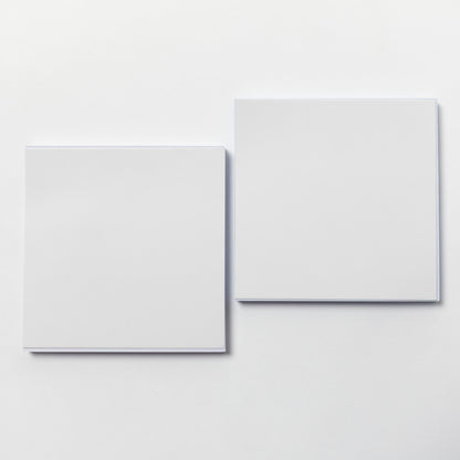 Two blank white square cards or sheets of paper arranged side by side on a clean white background.