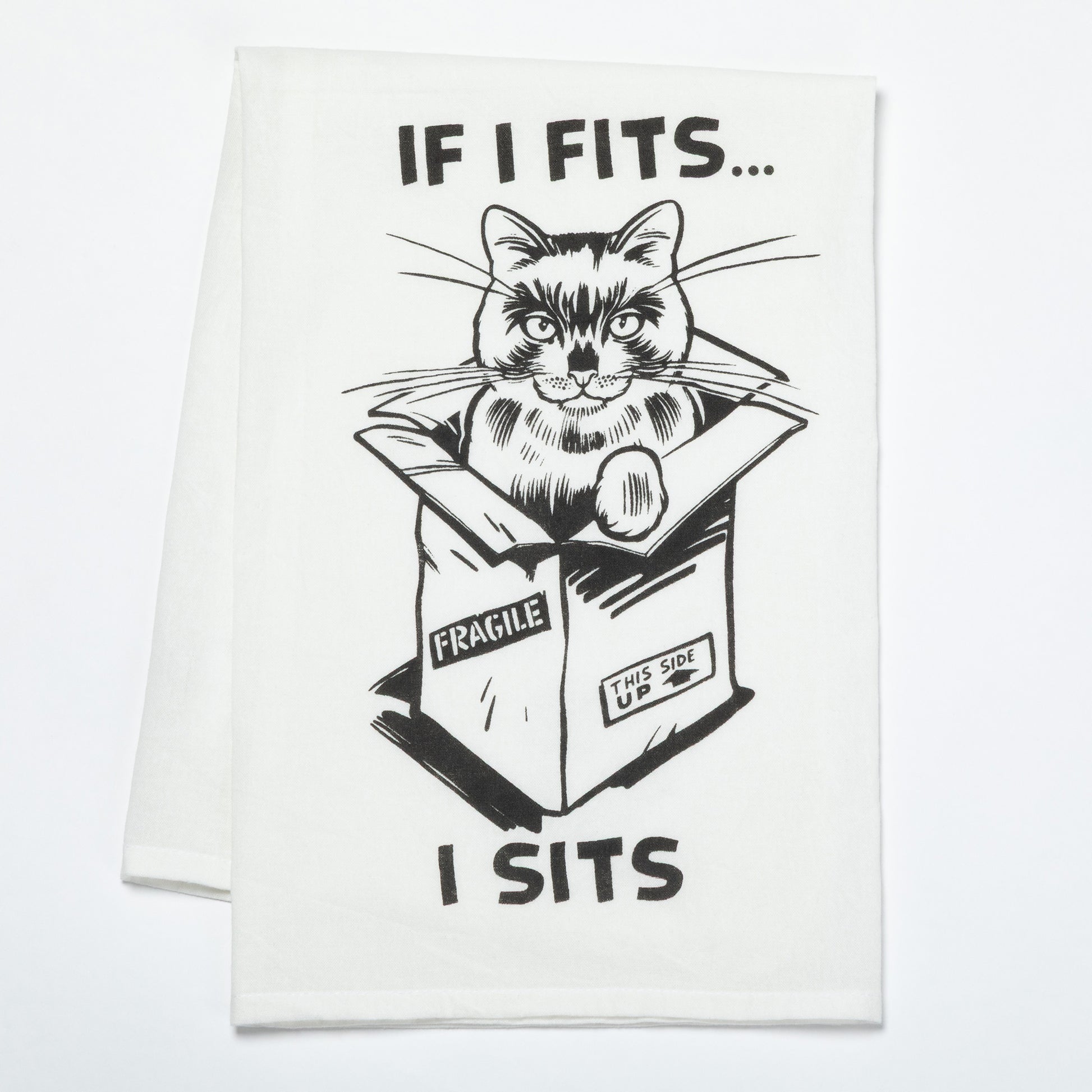 Cat in a box with humorous text on a white dish towel