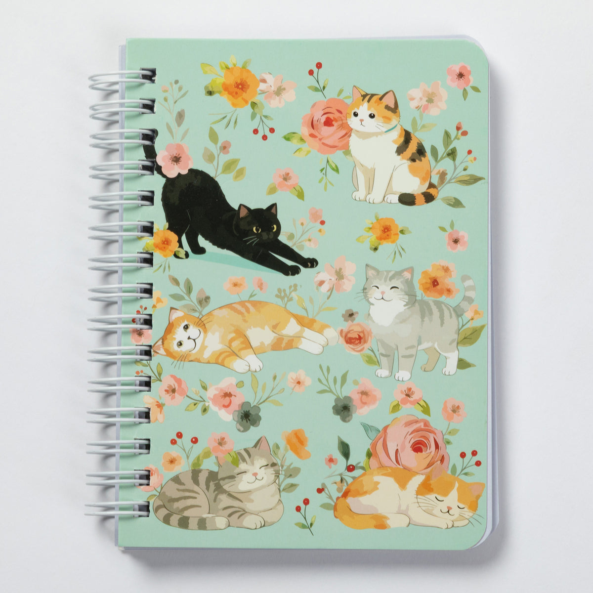 A spiral-bound notebook with a mint green cover decorated with watercolor illustrations of various cats and pink, orange, and yellow flowers, shown on a light gray background.