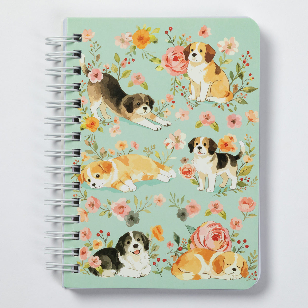 A spiral-bound notebook with a mint green cover decorated with watercolor illustrations of beagle dogs and pink, orange, and yellow flowers, shown on a light gray background.