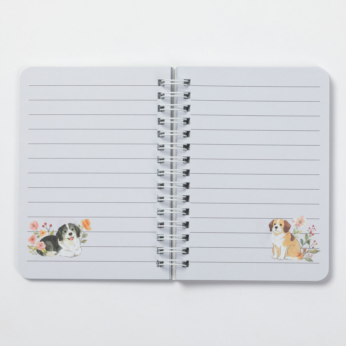 An open spiral-bound lined notebook on a light gray background. The pages are white with horizontal lines, and there are small watercolor illustrations of dogs near the bottom left and bottom right corners.