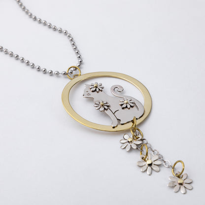 A silver ball chain car charm featuring a circular pendant with a silver cat silhouette and flower details, accented by a gold-tone ring and matching dangling flower charms, shown on a light gray background.
