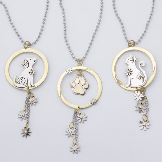 Three gold and silver pet memorial necklaces with circular pendants featuring dog, cat, and paw print designs, shown on a light gray background.