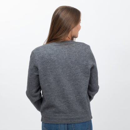 A woman viewed from behind wearing a dark gray knit sweater and blue jeans against a plain white background.