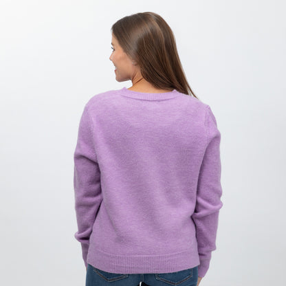 A woman viewed from behind wearing a light purple knit sweater and blue jeans against a plain white background.