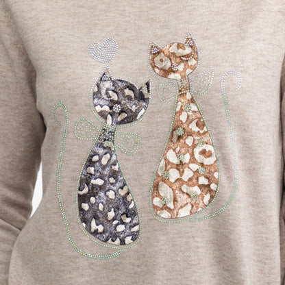 A close-up of a light heather gray sweatshirt featuring a graphic of two stylized cats adorned with rhinestone patterns and bows.