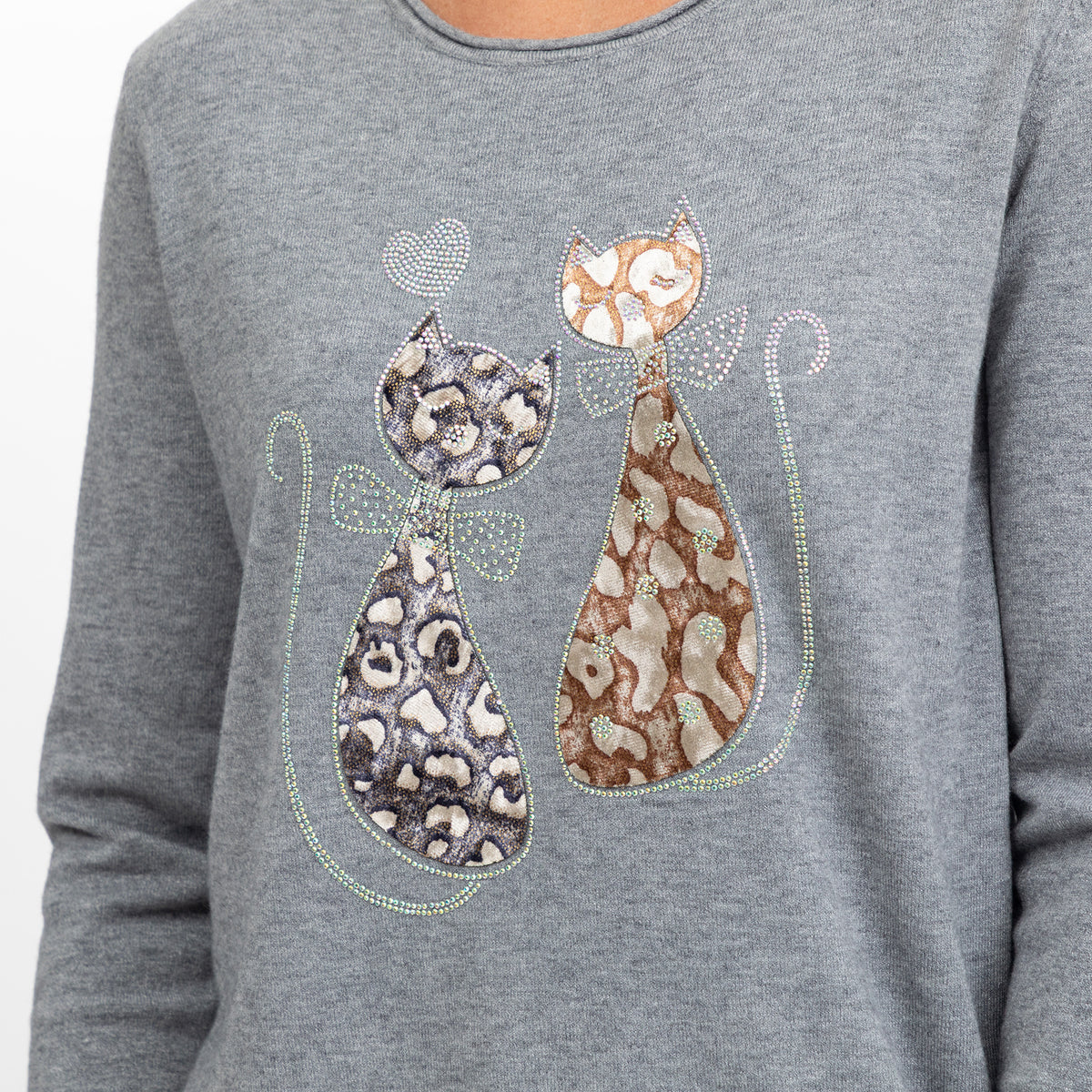 A close-up of a heather gray long-sleeve top featuring a rhinestone-embellished graphic of two stylized cats in leopard and mottled patterns, with a small heart above them.