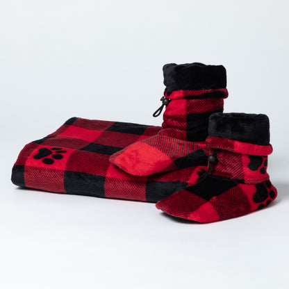 A matching pet fleece blanket and booties set in red and black buffalo plaid with black paw print details and plush black lining.