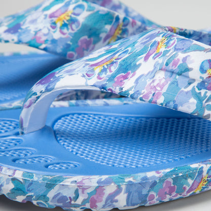 A pair of blue and purple EVA flip flops with marble paw garden paw print design, detail shot showing off the design and the foot bed