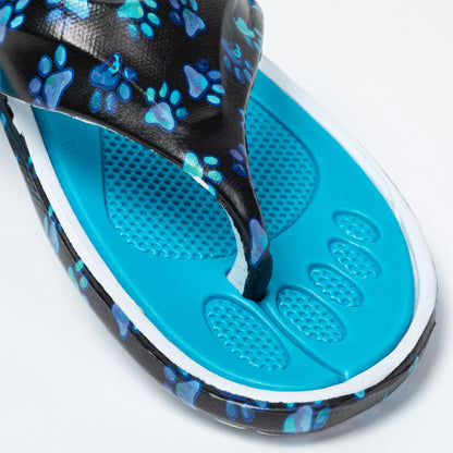 Black sandal with blue paw print pattern, and a blue textured insole, on a white background
