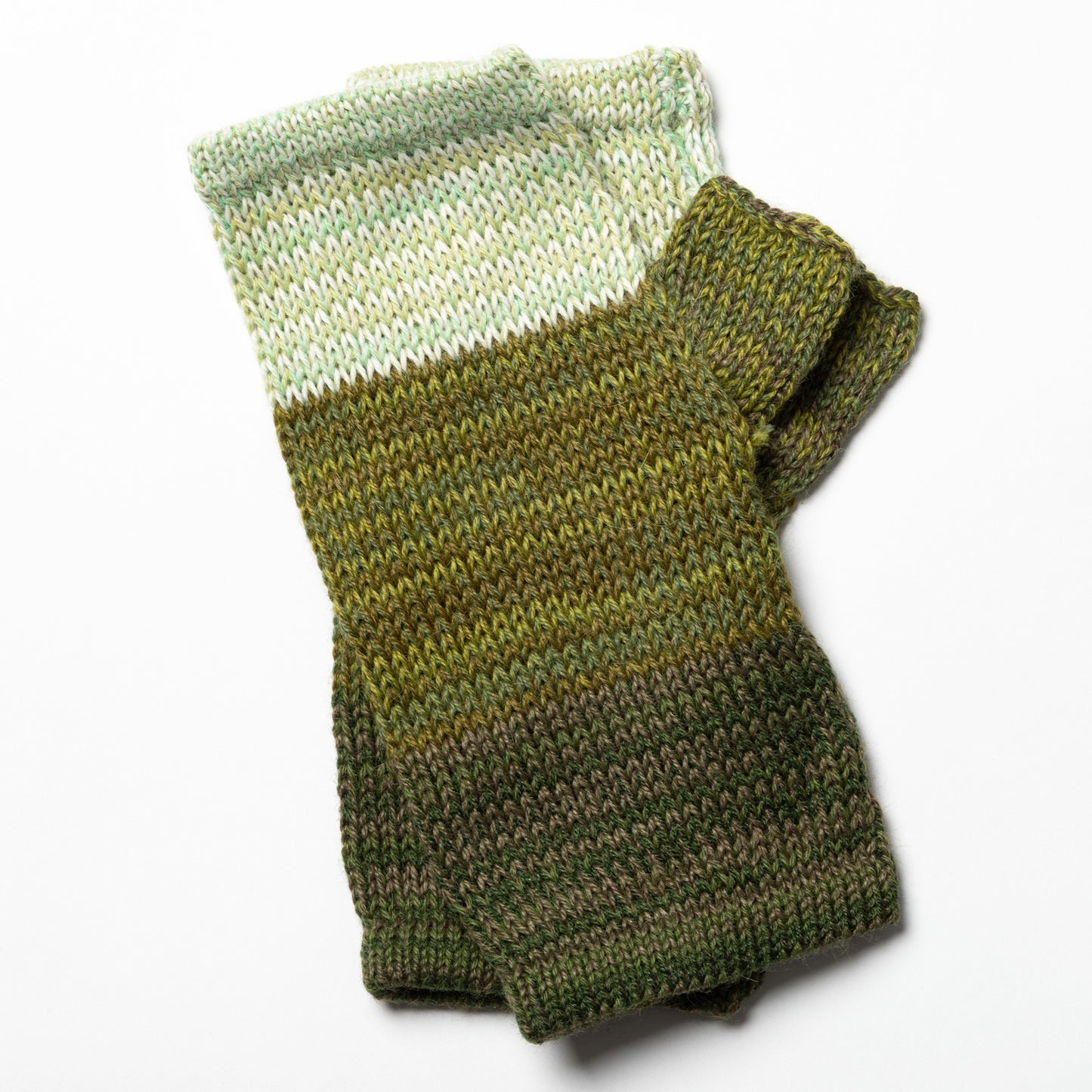 Knitted green and white fingerless mittens on a white background