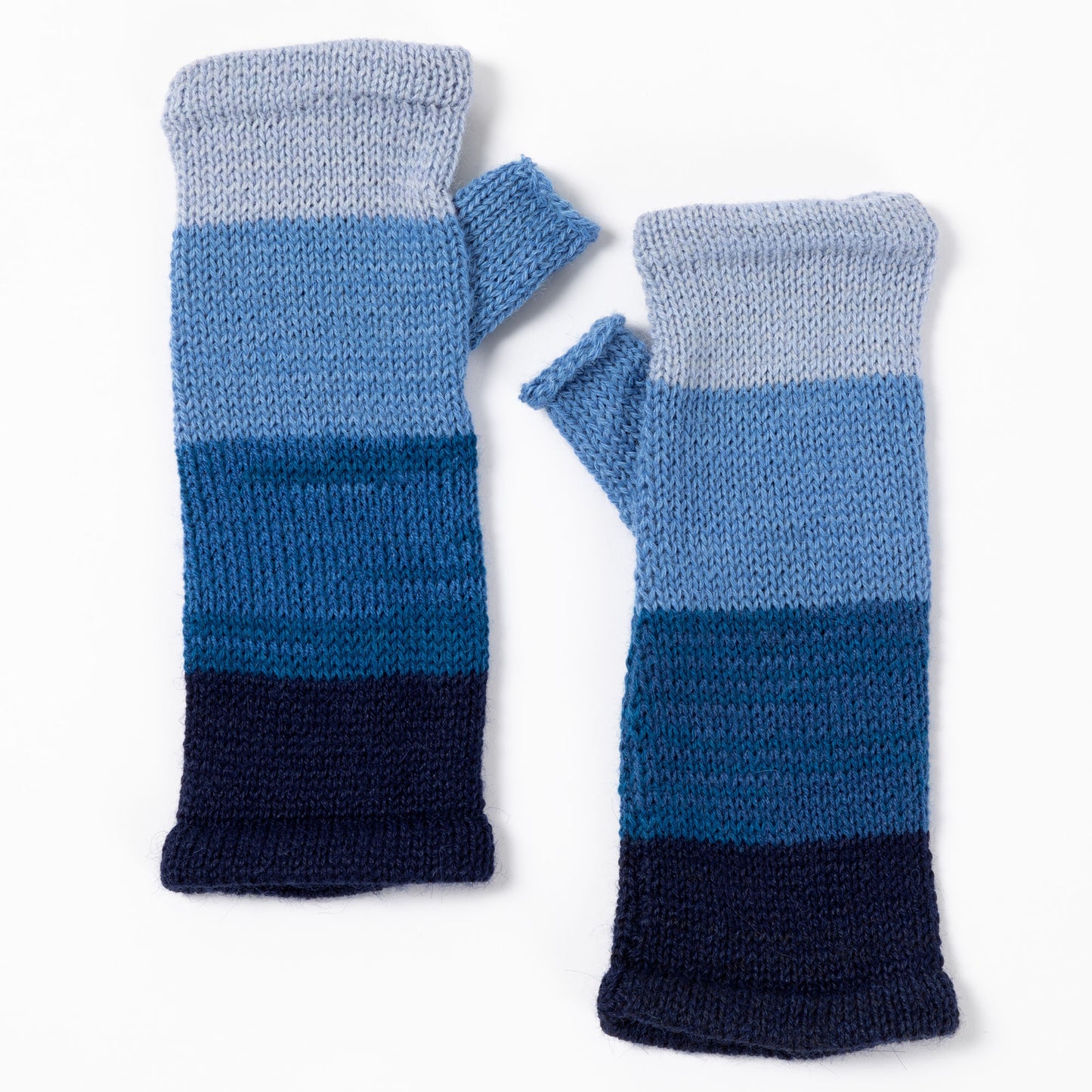 a pair of alpaca fingerless mittens in shades of blue made from alpaca wool on a white background