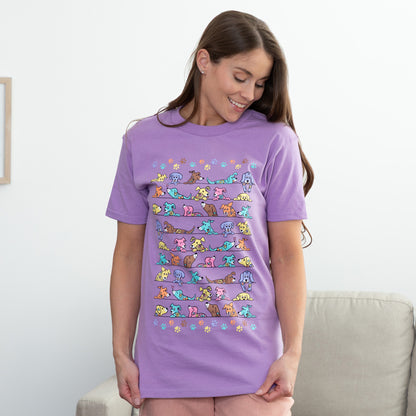 Woman wearing a purple t-shirt with colorful dog pattern in front of a couch.