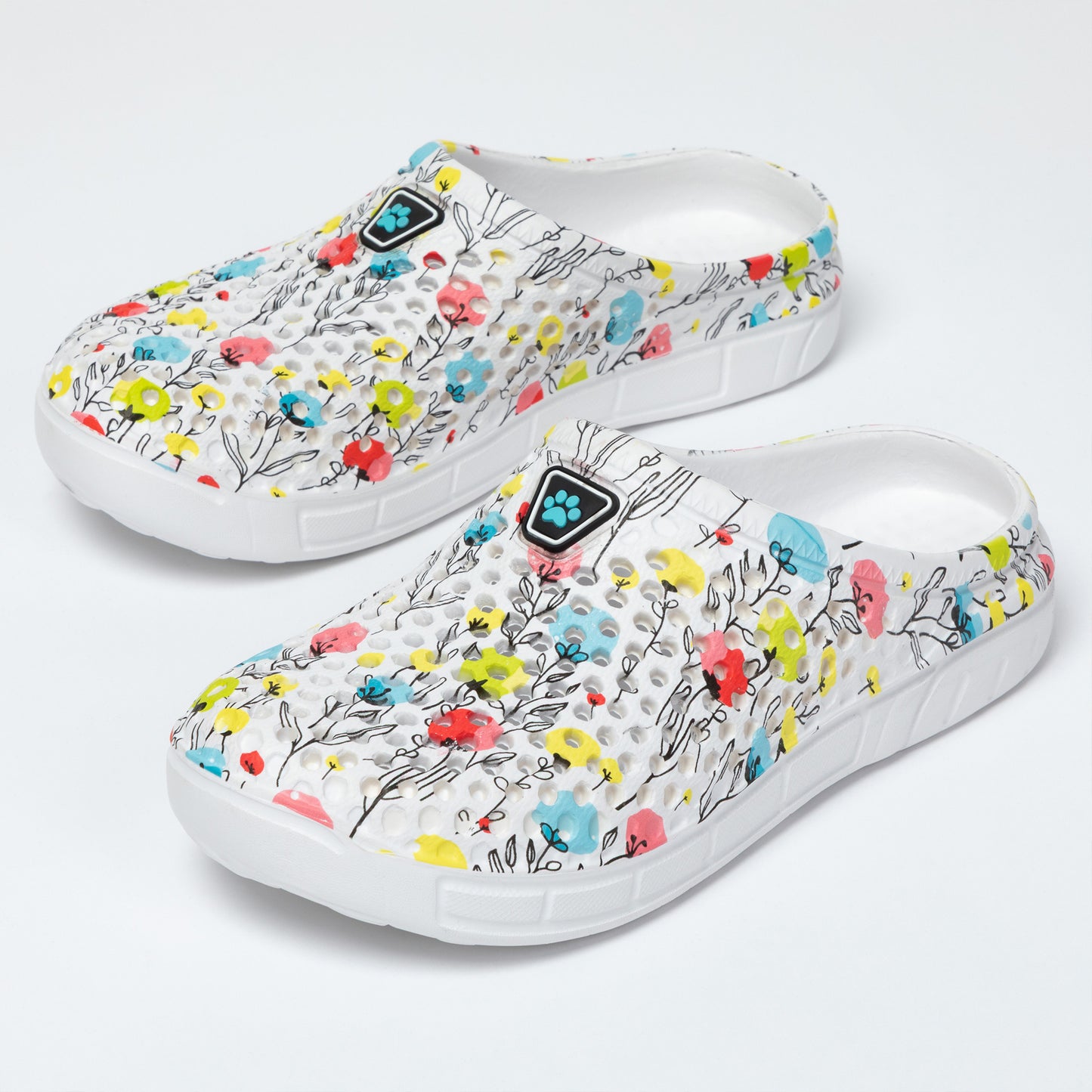 White clogs with colorful floral pattern on a light gray background