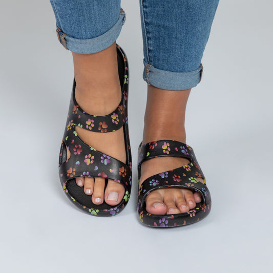 Ombre paw with hearts Black sandals with color paw print pattern worn with rolled-up jeans on a light gray background