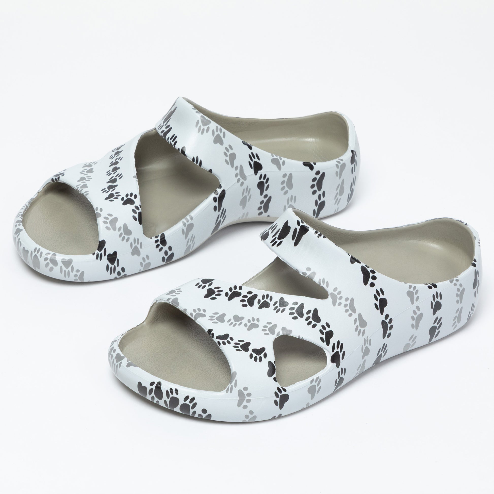 White sandals with black paw print pattern on a white background