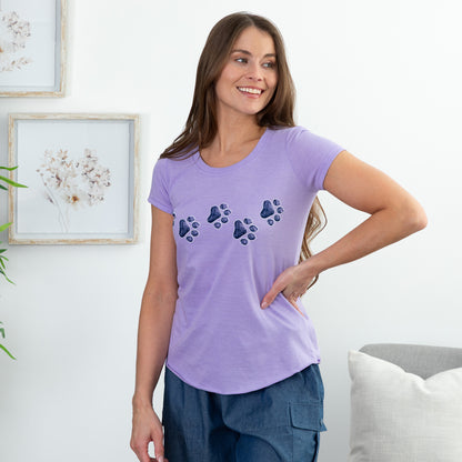 Woman wearing a purple t-shirt with paw print design in a home setting