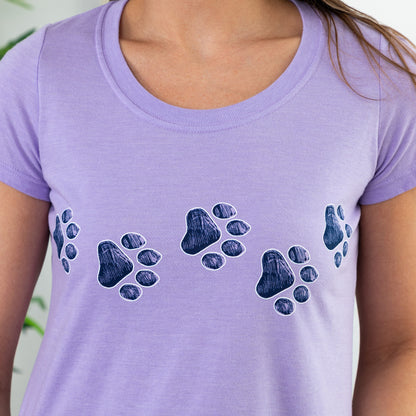 Purple t-shirt with blue paw prints worn by a person