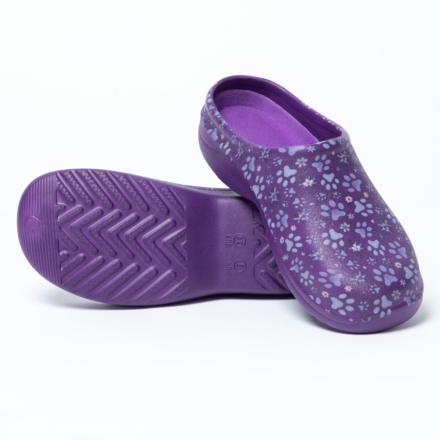 Purple clogs with floral paw print pattern, with a textured sole, on a white background