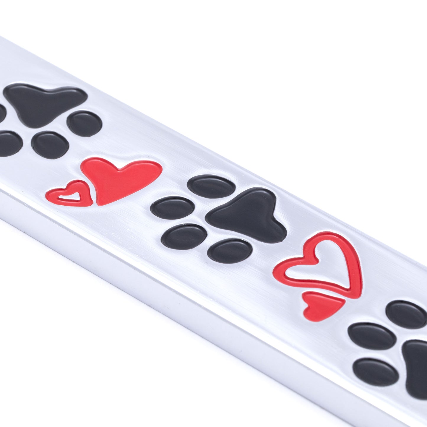 Close up of a license plate frame with black paw prints and red hearts on a white background