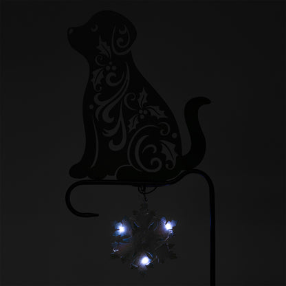 Decorative metal dog silhouette with embedded lights on a black background