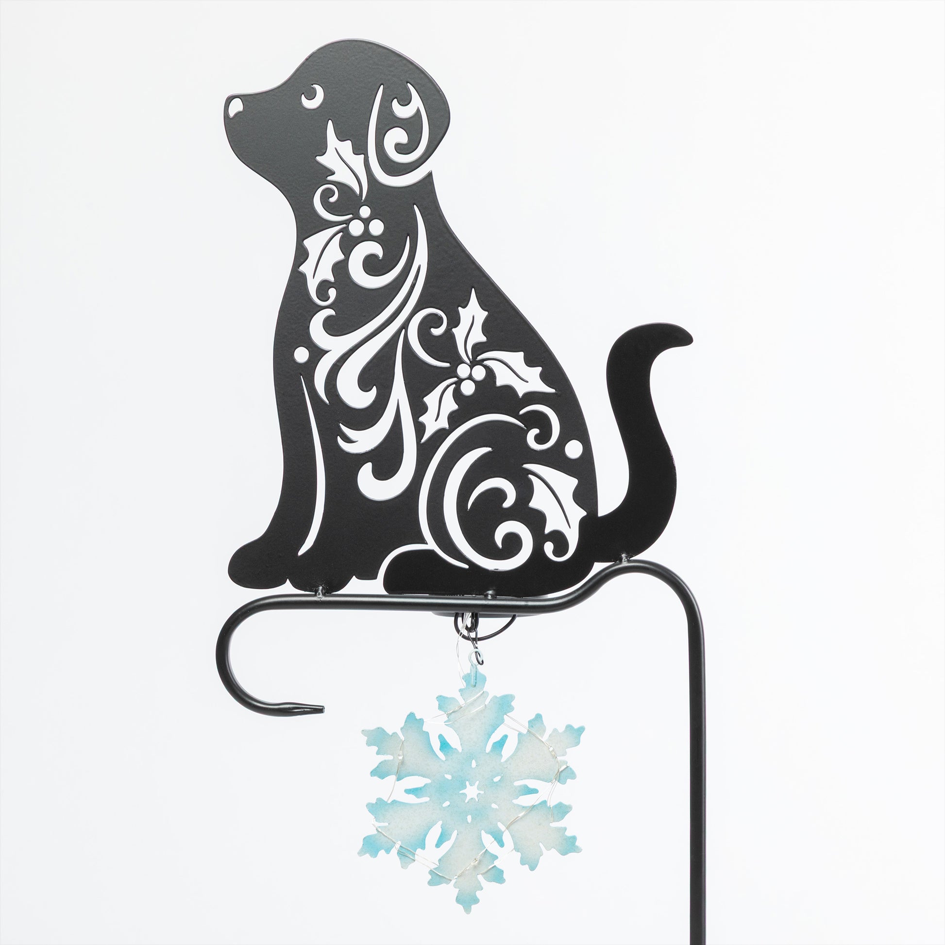 Decorative metal dog silhouette with floral patterns and a snowflake ornament on a white background