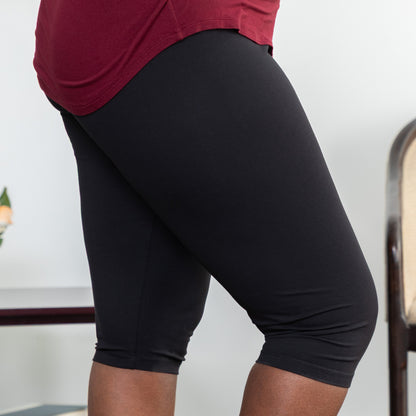 Person wearing black capri leggings with a blurred background