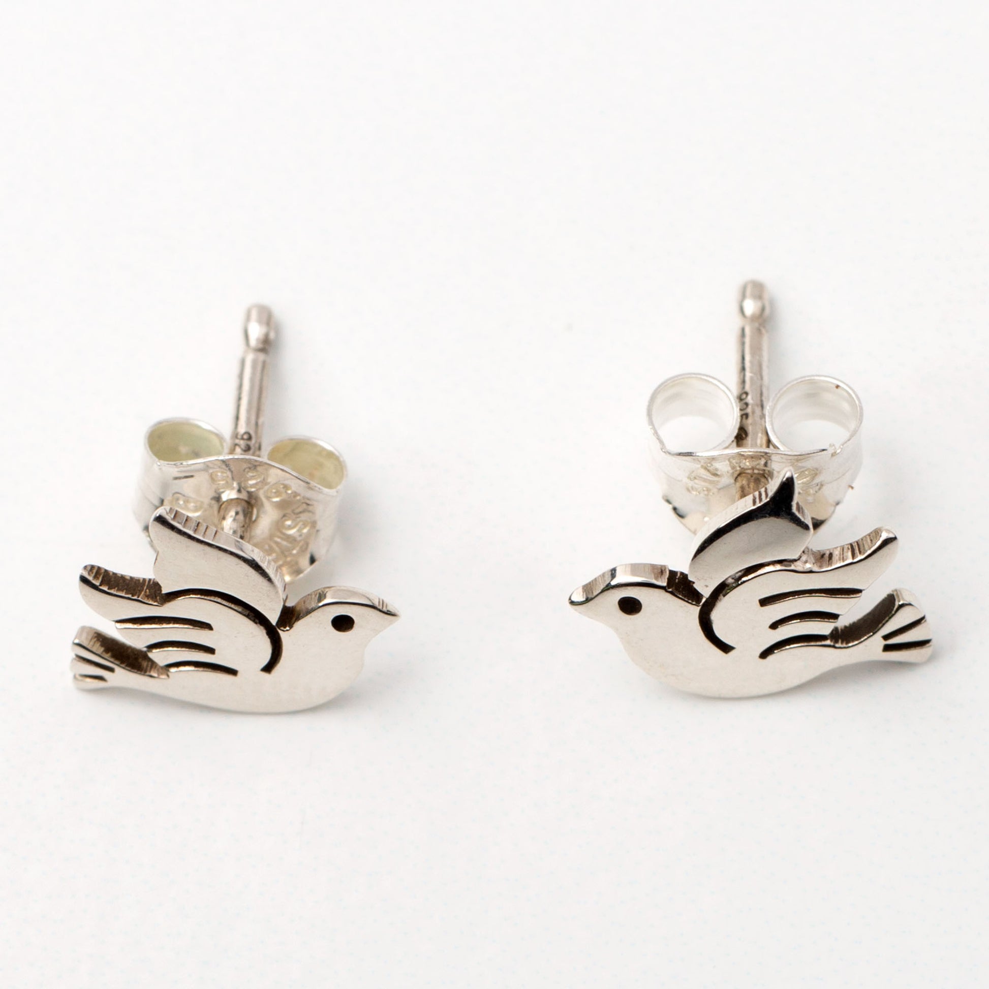 Silver bird-shaped earrings on a white background