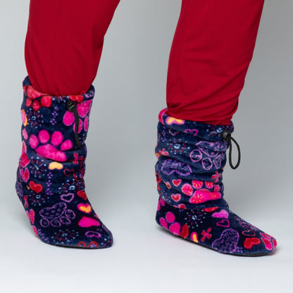 Navy blue fleece slipper booties with bright pink hearts and paw prints all over, against a white background.