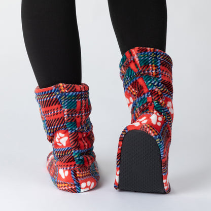 A pair of plush knit booties with a red, blue, and white plaid pattern and white paw prints, shown on a model wearing black tights against a light gray background.