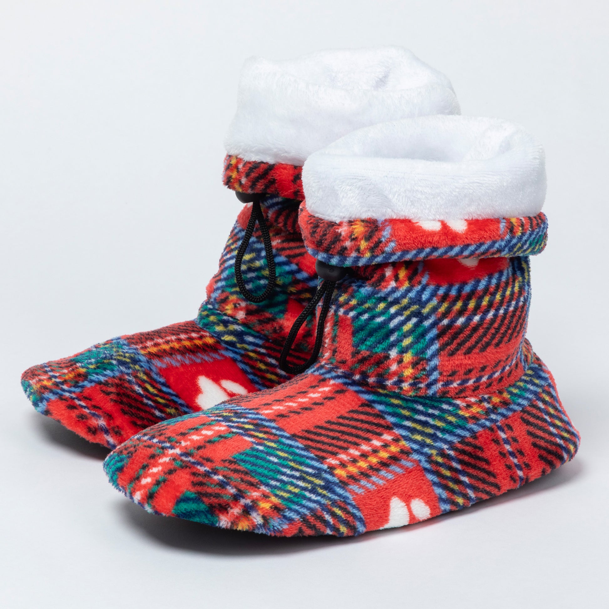 A pair of plush slipper boots with a festive red, green, and blue tartan plaid pattern, featuring a thick white faux-fur trim and black drawstrings, set against a plain light gray background.