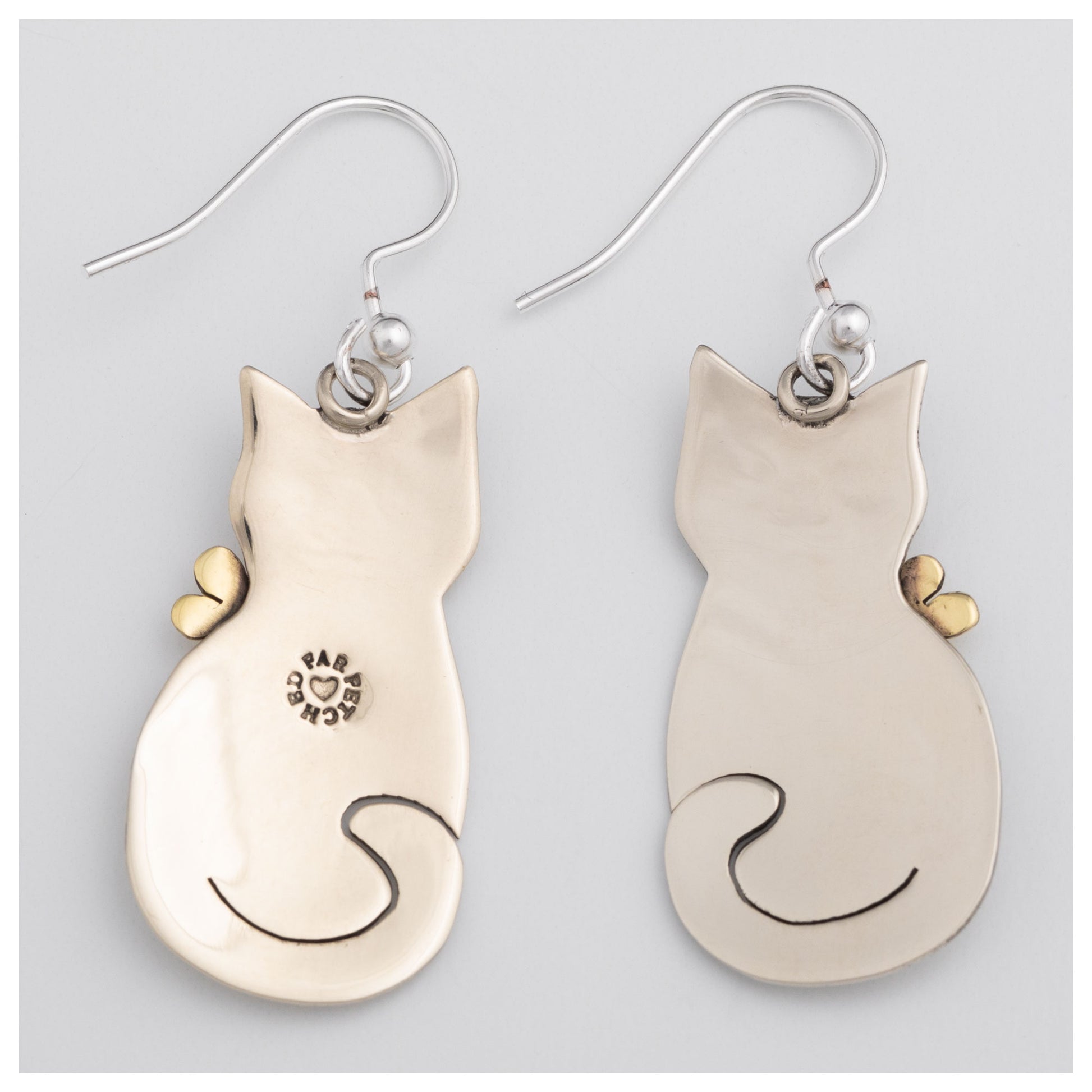 The back of cat-shaped earrings on a light gray background