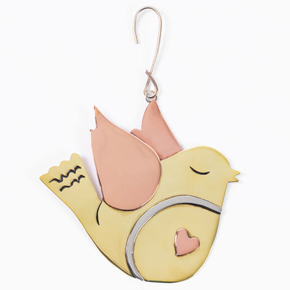 Decorative brass bird ornament with copper heart on a white background.