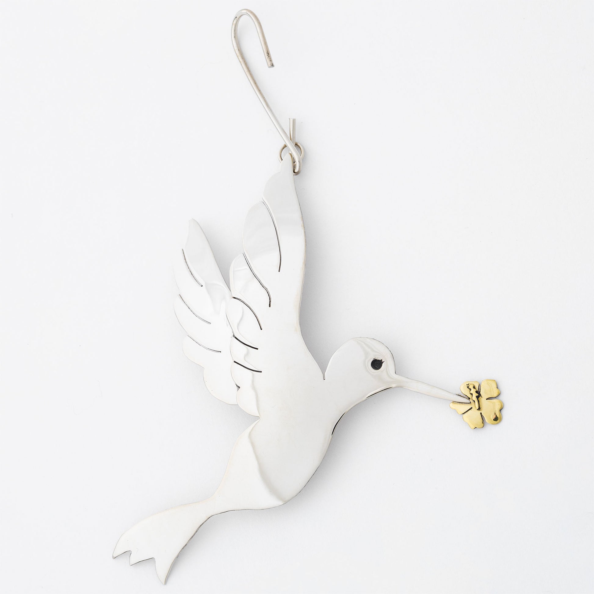 Silver tone dove ornament with gold olive branch on a white background