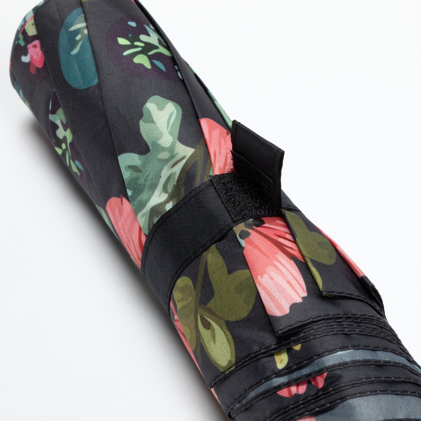 Floral-patterned umbrella with a black strap on a white background