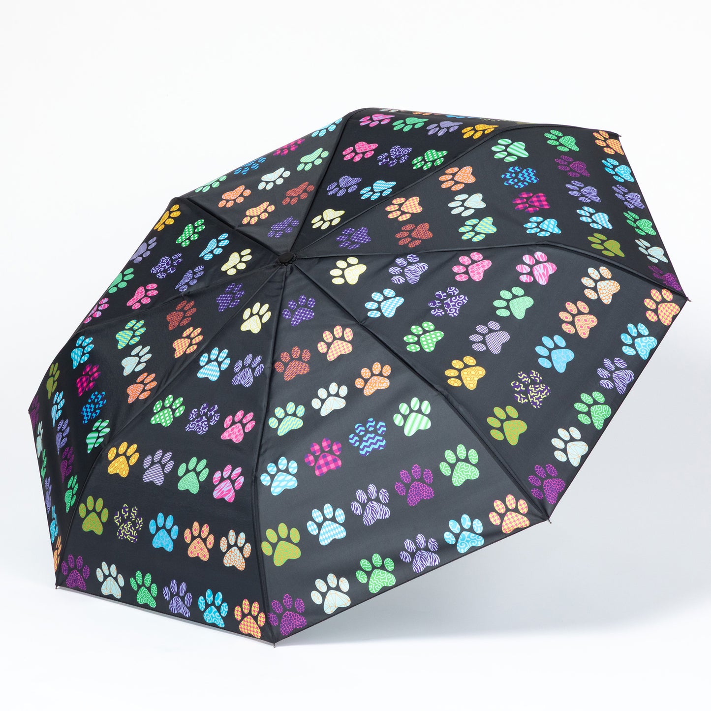 Black umbrella with colorful paw print pattern on a white background