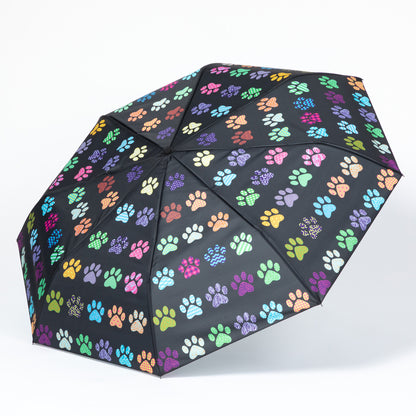 Black umbrella with colorful paw print pattern on a white background