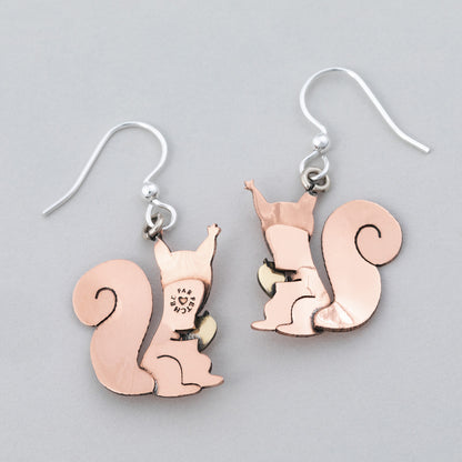 Backs of Squirrel-shaped copper earrings on a gray background.
