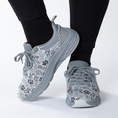 Gray paw print patterned sneakers worn with black leggings on a white background