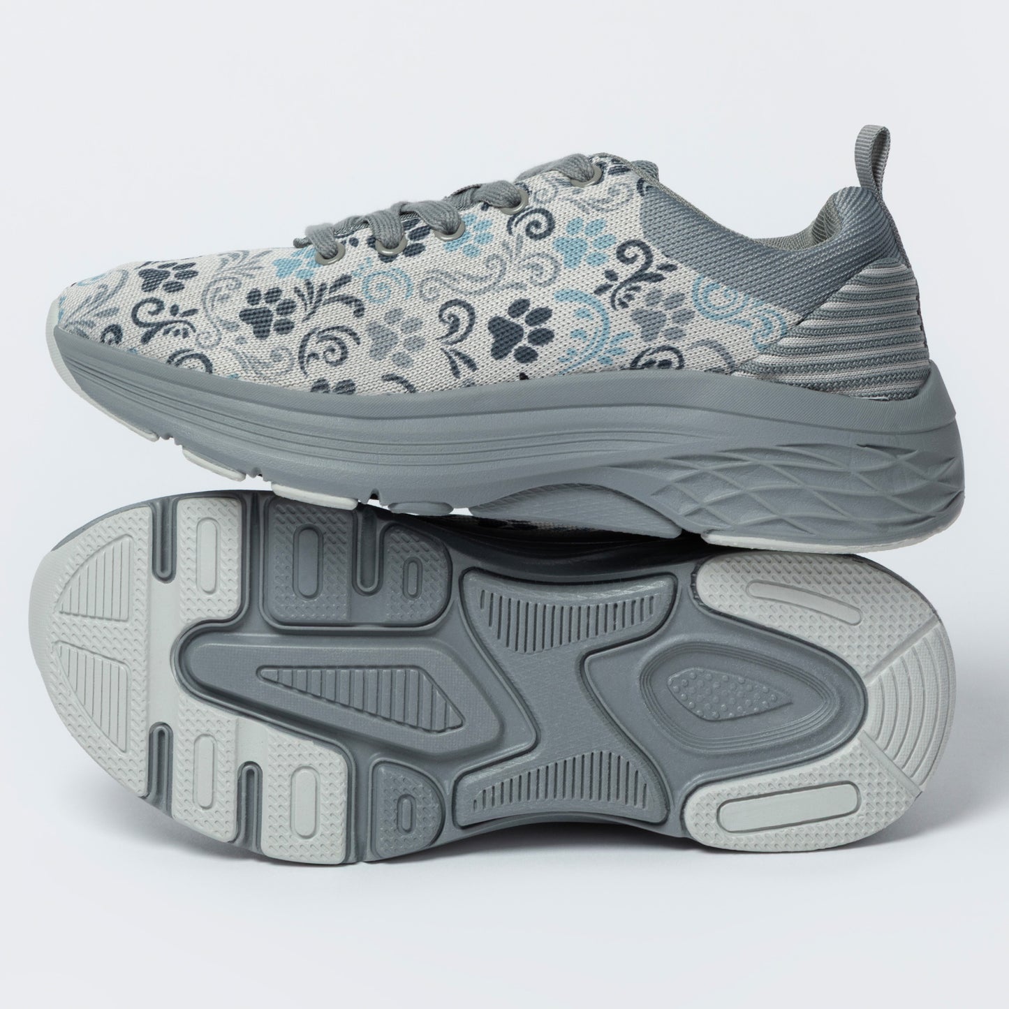 Gray sneakers with a deep textured outsole, featuring a paw print and floral pattern, on a white background.