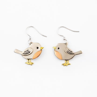 Bird-shaped silver earrings with brass and copper accents on a white background.