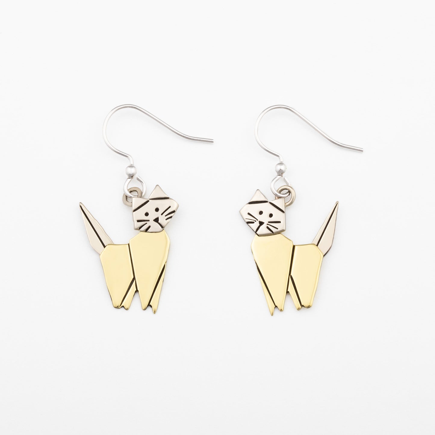 Brass and silver cat-shaped earrings on a white background