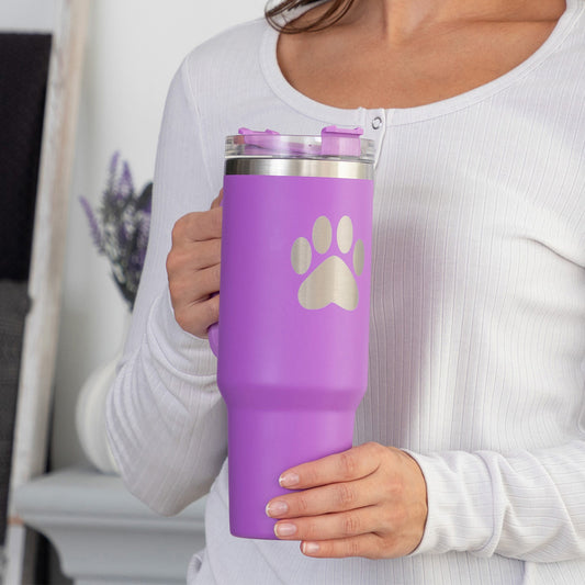 40 oz tumbler with a paw print in fuchsia, being held by a woman with a white background.