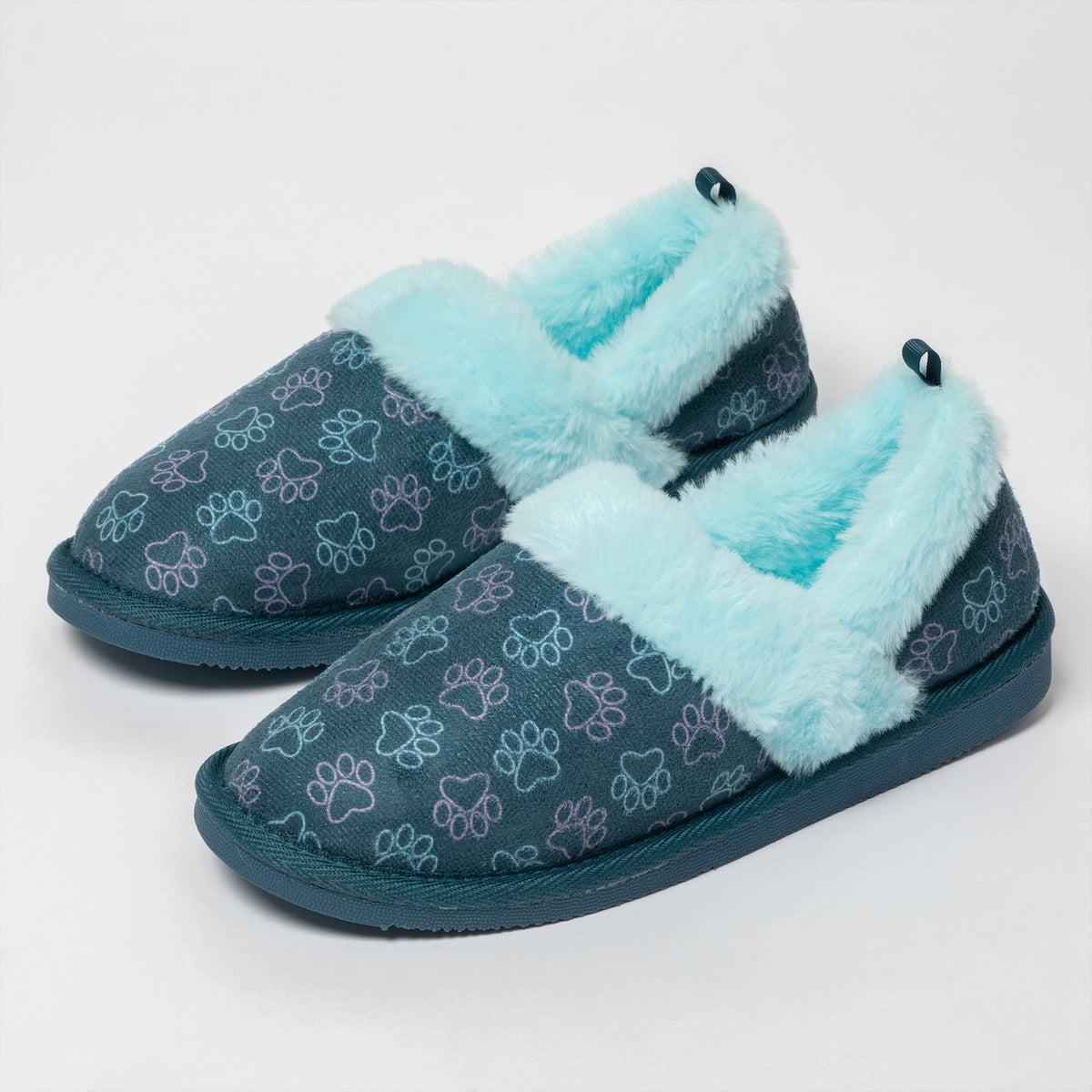 A pair of slip-on slippers with a dark teal-blue fabric upper covered in a light blue and purple paw print pattern, featuring fluffy light blue faux-fur trim around the opening and sole.