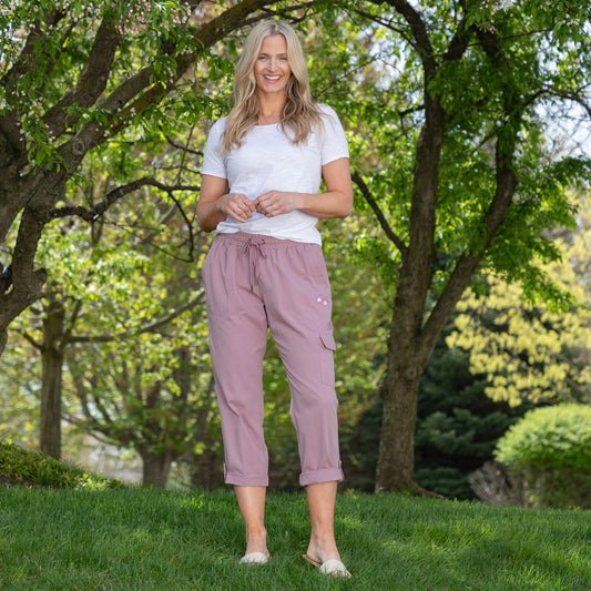 Woman in white t-shirt and pink pants standing in a park